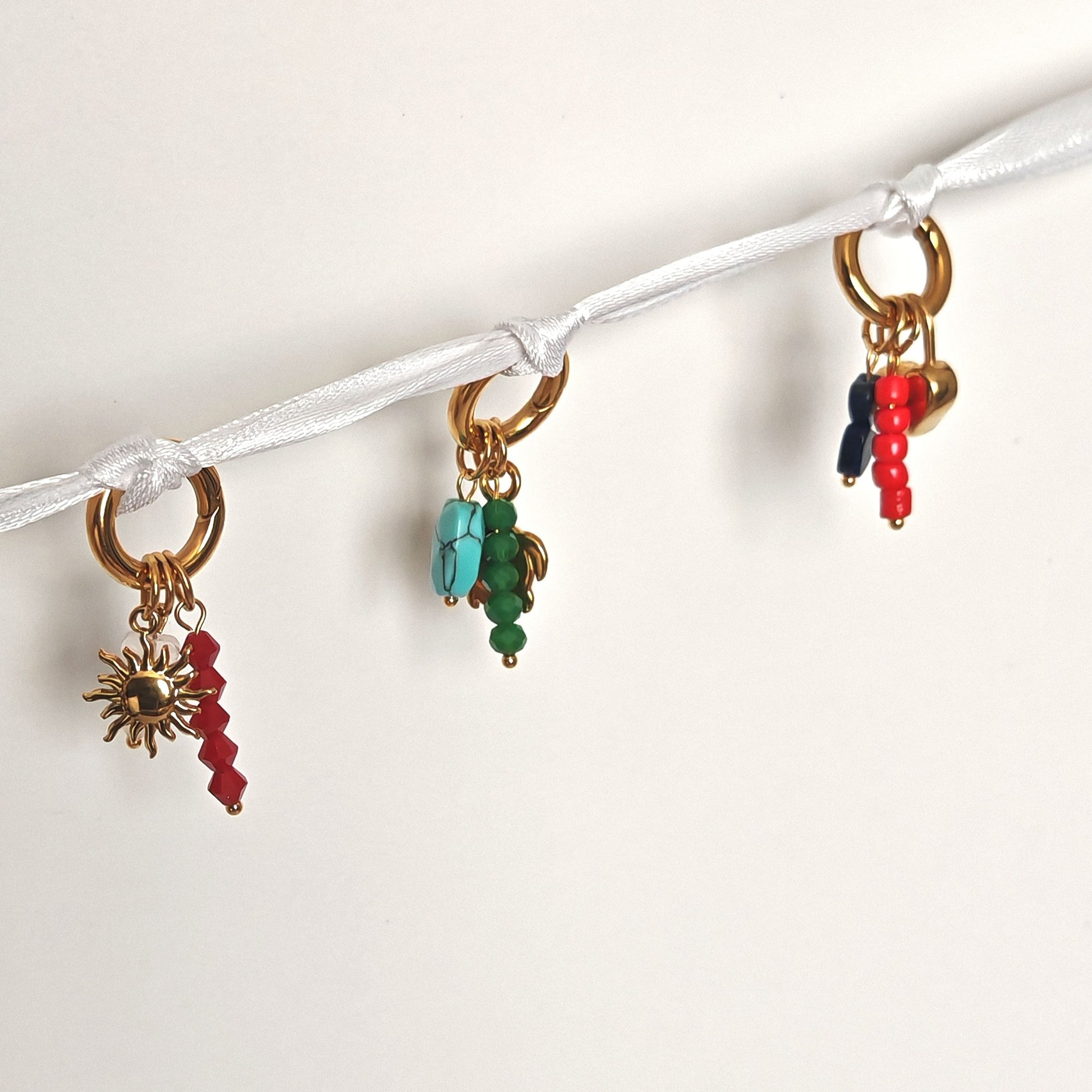 Charmuri personalizate pentru adidași – accesorii aurii cu detalii roșii, bleumarin, verzi și turcoaz.