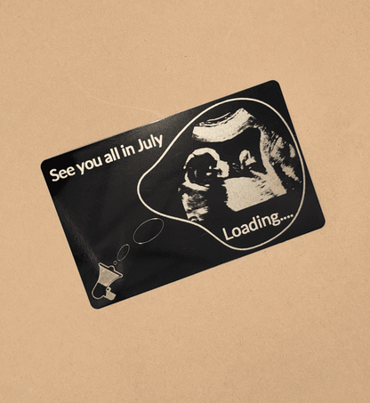 Card anunț sarcină cu imagine stilizată de ecografie și text „See you all in July – Loading…” pe fundal negru