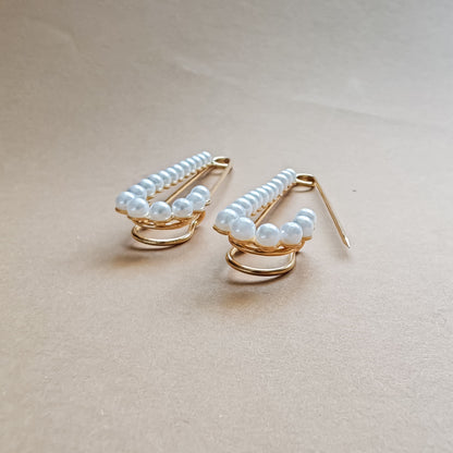 Accesoriu tip broșă cu aspect glam, realizat din metal auriu și perle – ideal pentru styling creativ.